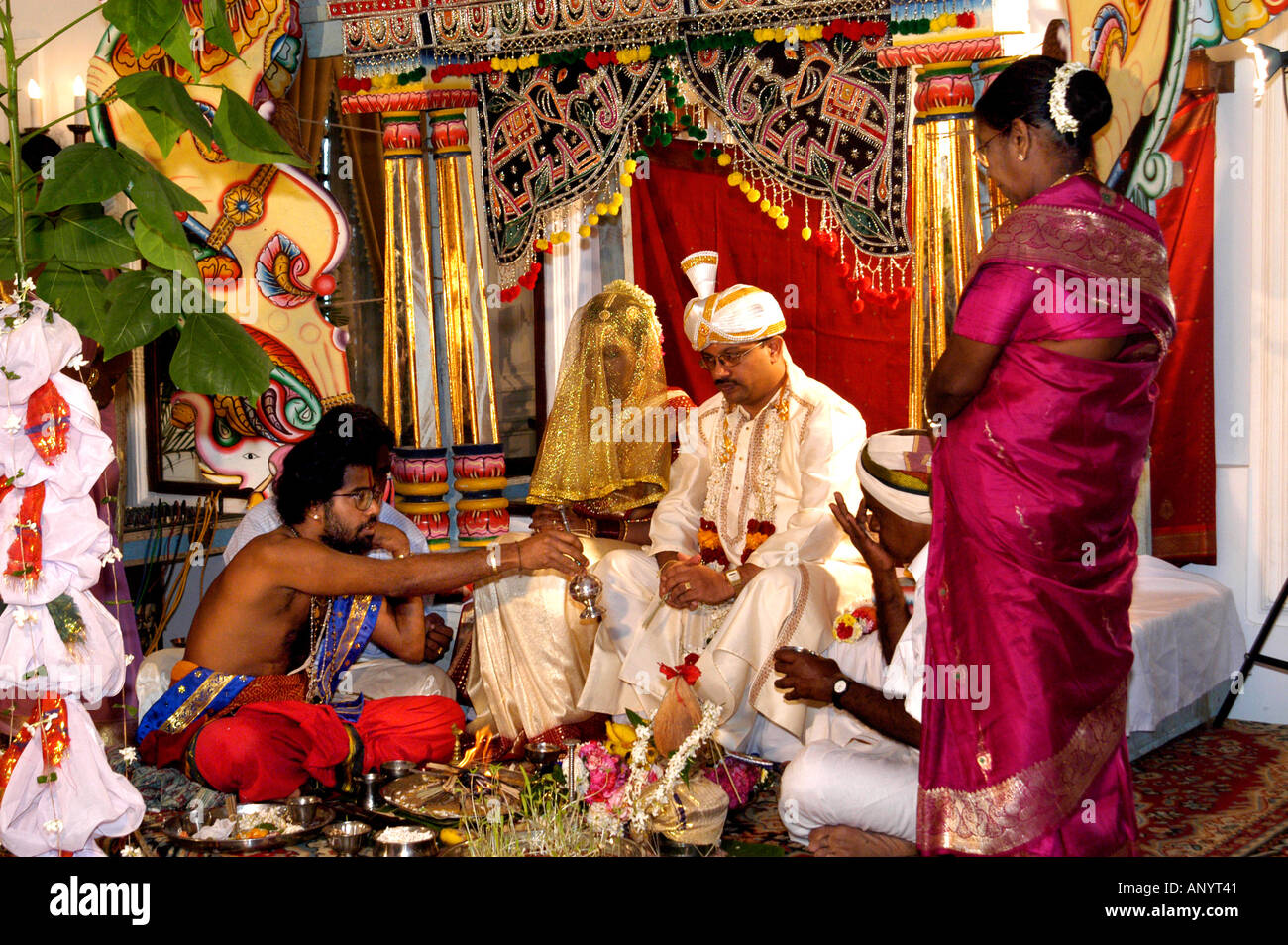 Traditionelle hinduistische Hochzeitszeremonie auf einer kunstvollen Bühne mit einem Priester, der heilige Rituale für die Braut und den Bräutigam Sri Lanka Ceylon vorführt. Stockfoto