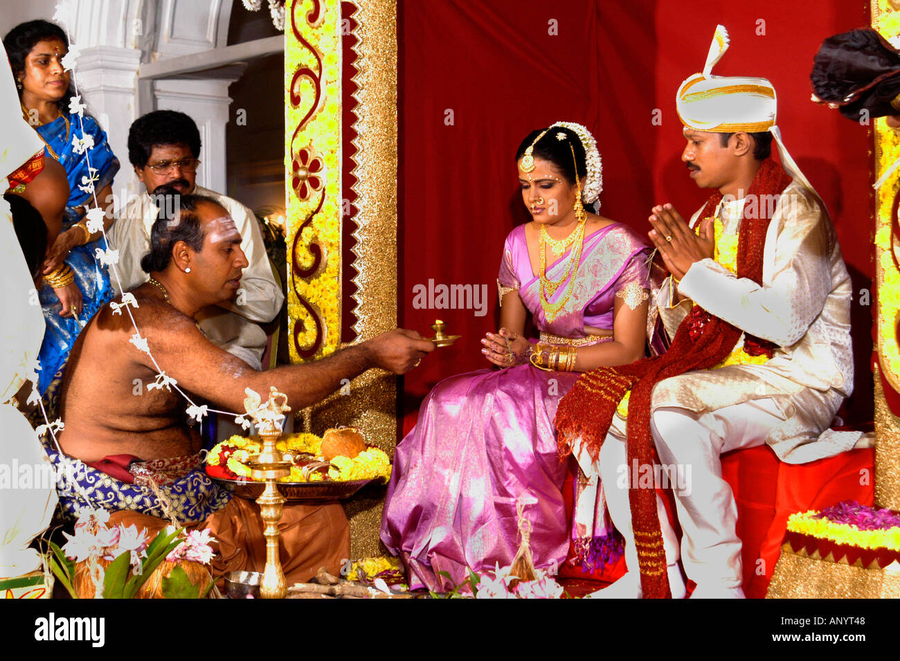 Traditionelle hinduistische Hochzeitszeremonie auf einer kunstvollen Bühne mit einem Priester, der heilige Rituale für die Braut und den Bräutigam Sri Lanka Ceylon vorführt. Stockfoto