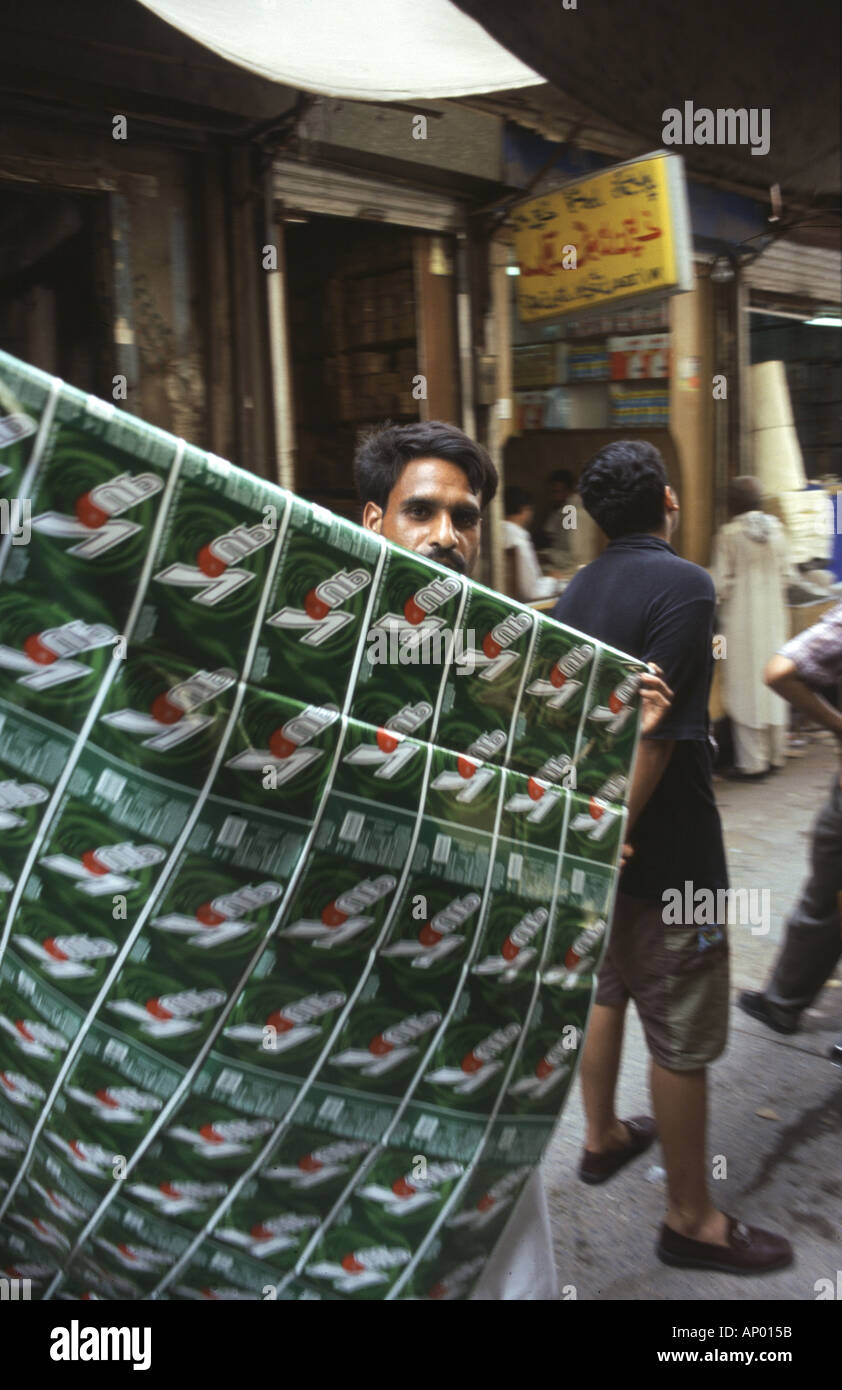 Ein Mann trägt geschmiedete Softdrink Etiketten auf einem Markt in Rawalpindi, Pakistan Stockfoto