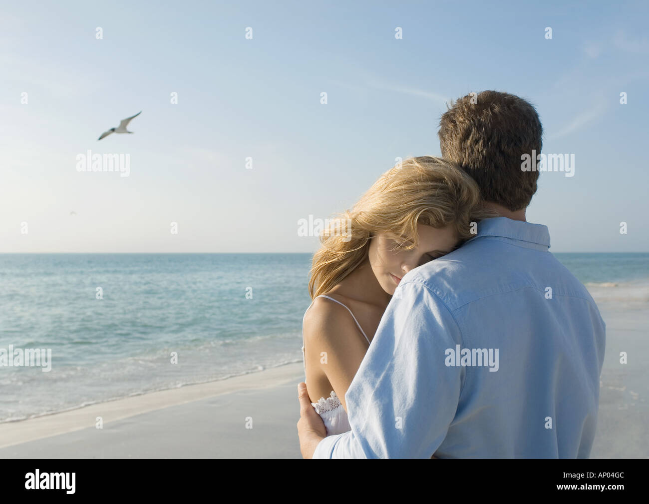 Paar am Strand umarmt Stockfoto
