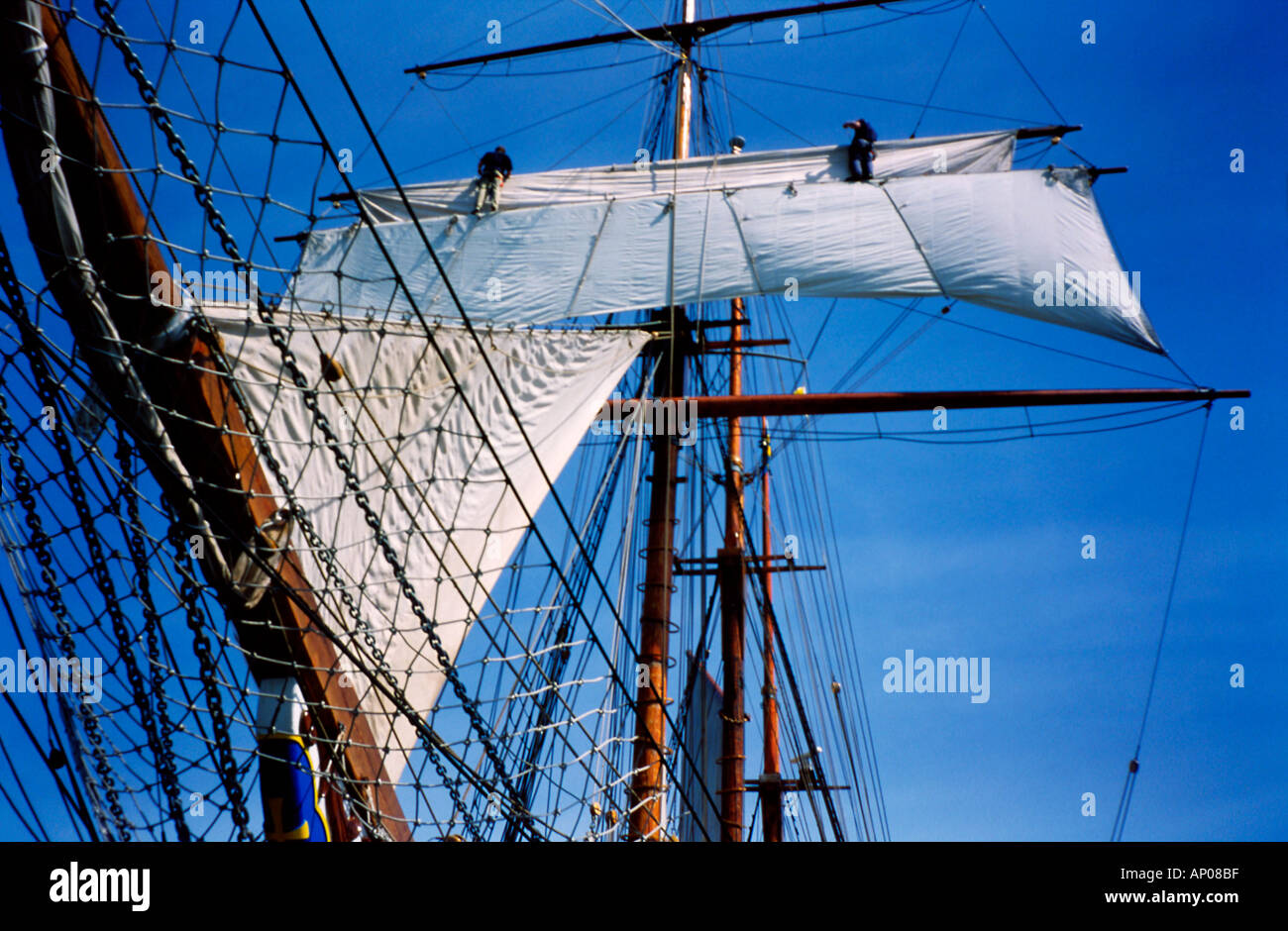 Drei Masten Topsail Schooner zwei Matrosen auf dem Hof unfurling einen quadratischem Segel Stockfoto