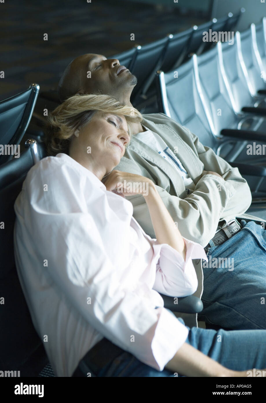 Paar, schlafen im Flughafen-lounge Stockfoto