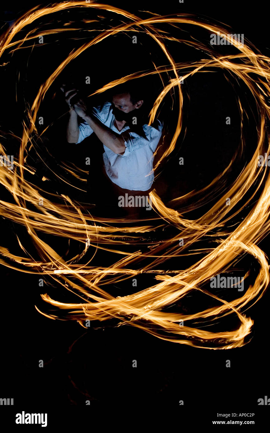 Mann Feuer tanzen mit Stöcken Feuer in der Nacht. Indien. Abstrakte Muster. Langzeitbelichtung Stockfoto