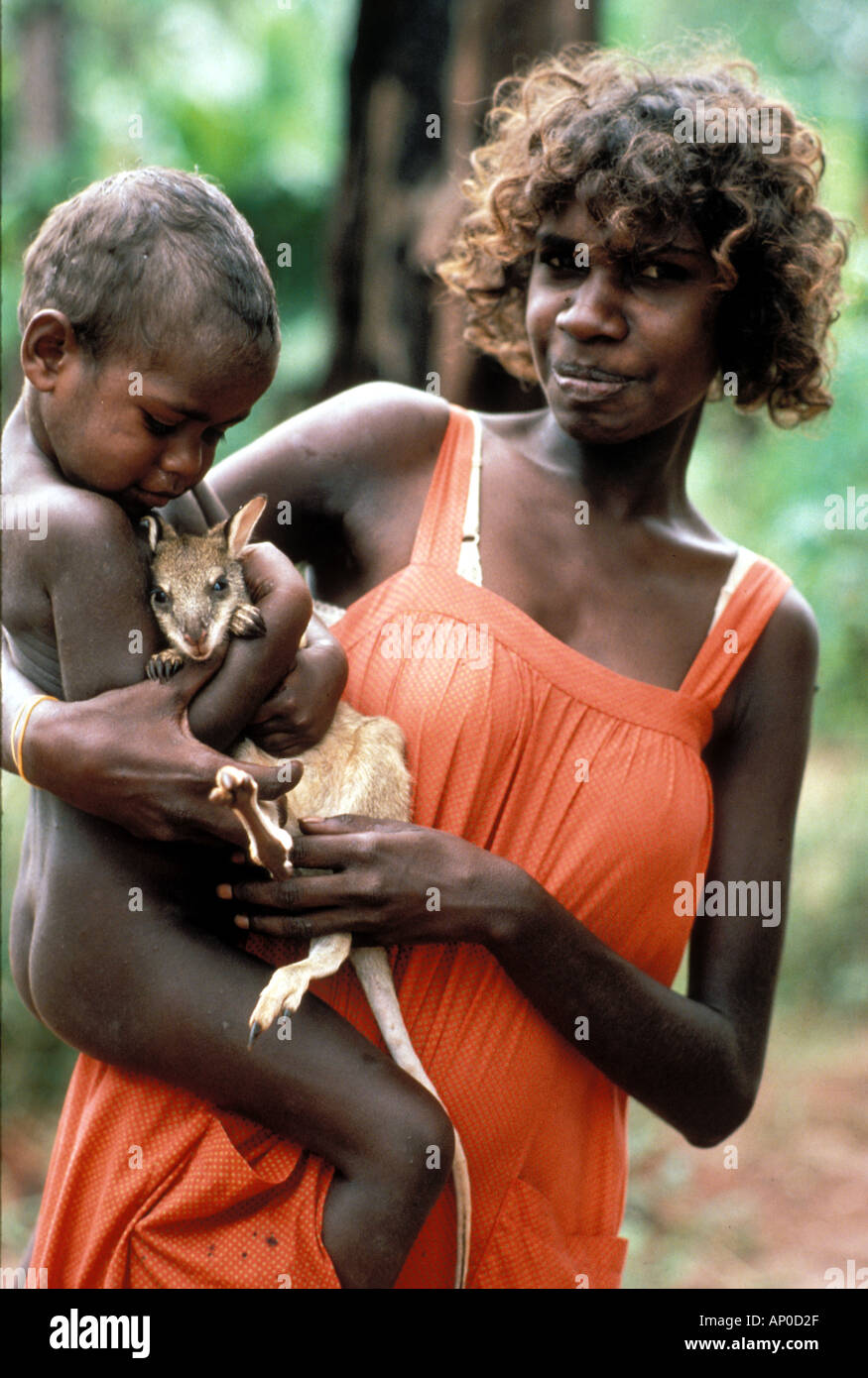 Aborigine-Frau mit ihrem Kind kuscheln Haustier Babykänguru dessen Mutter für Lebensmittel Arnhemland NT Australien getötet Stockfoto