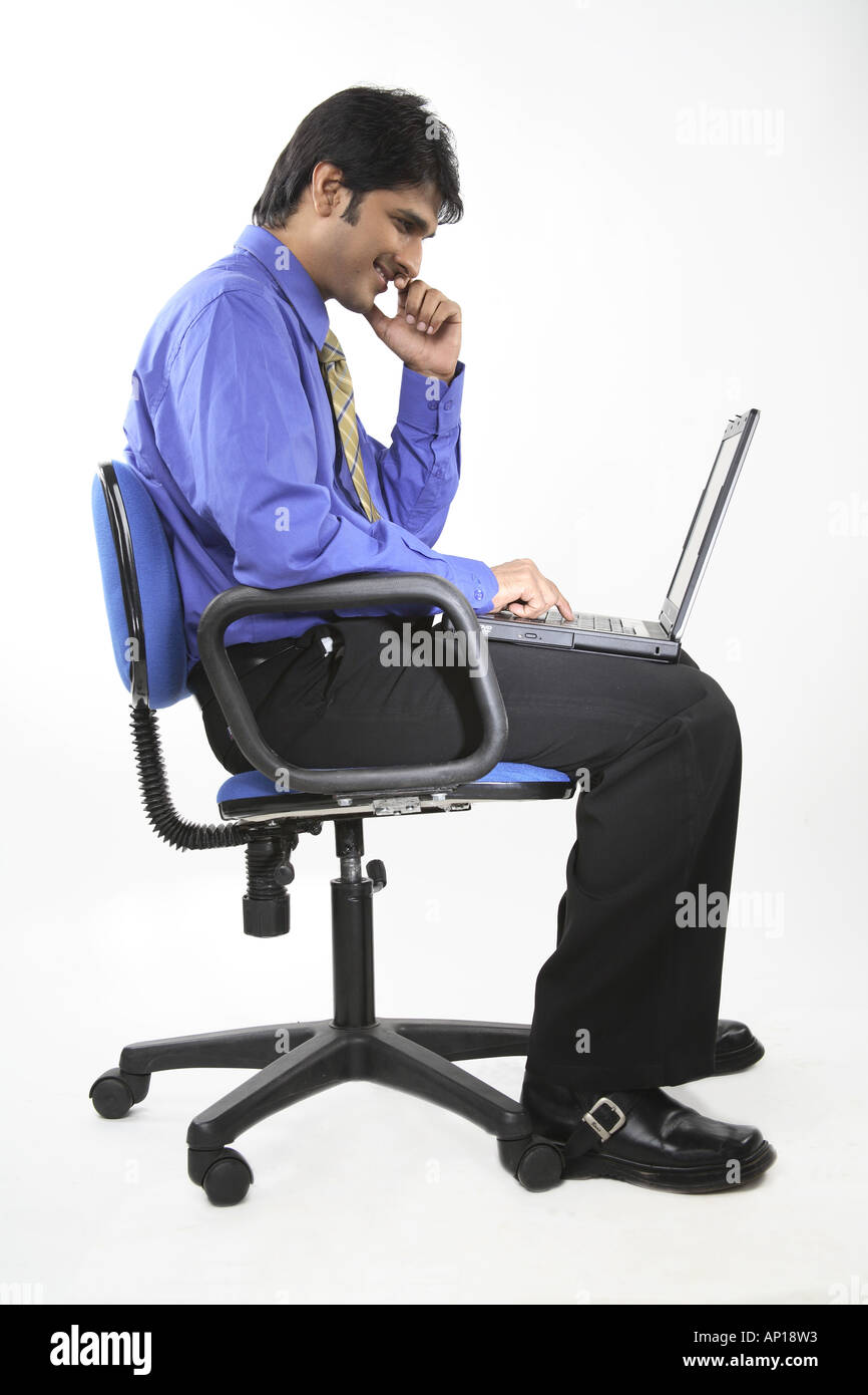 ANG200054 Executive ruht auf einem Stuhl mit Laptop auf dem Schoß Stockfoto