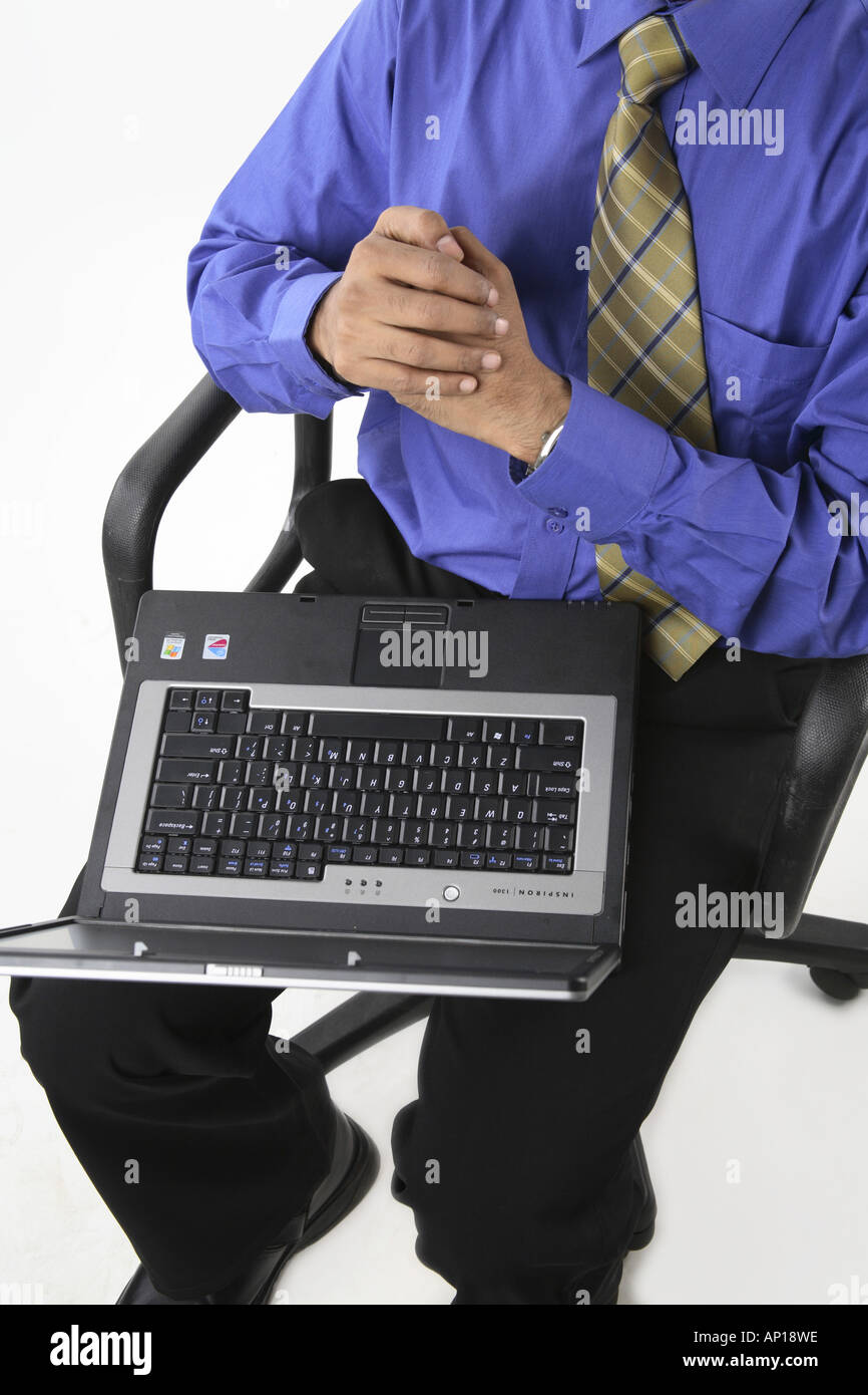 ANG200060 Executive ruht auf einem Stuhl mit Laptop auf dem Schoß, Hand in Hand oberen Winkel-Model-Release Nr. 687 M Stockfoto