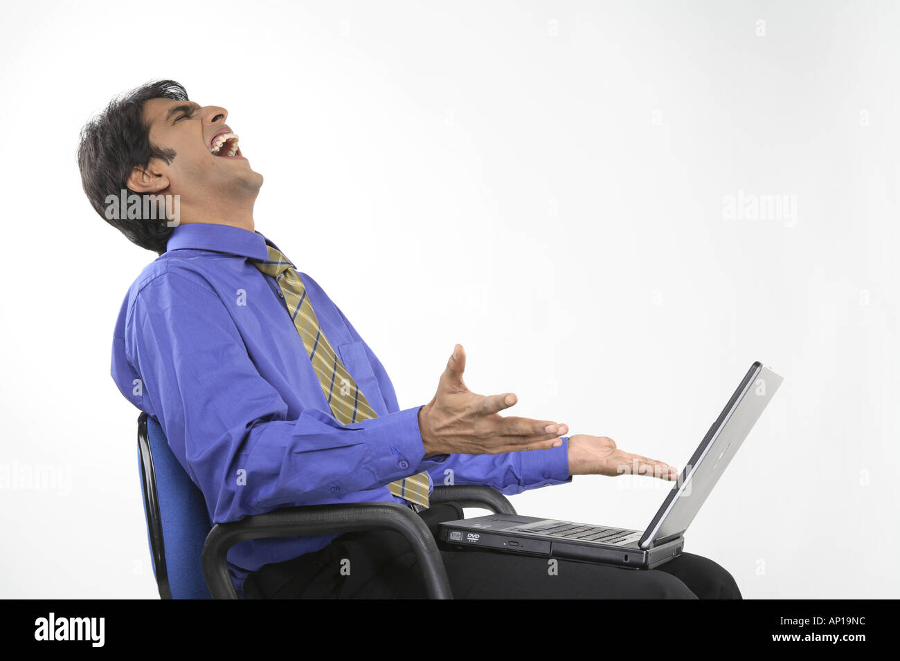 ANG200151 Executive ruht auf einem Laptop auf dem Schoß Lachen glücklich halten Stuhl Modell release Nr. 687 M Stockfoto