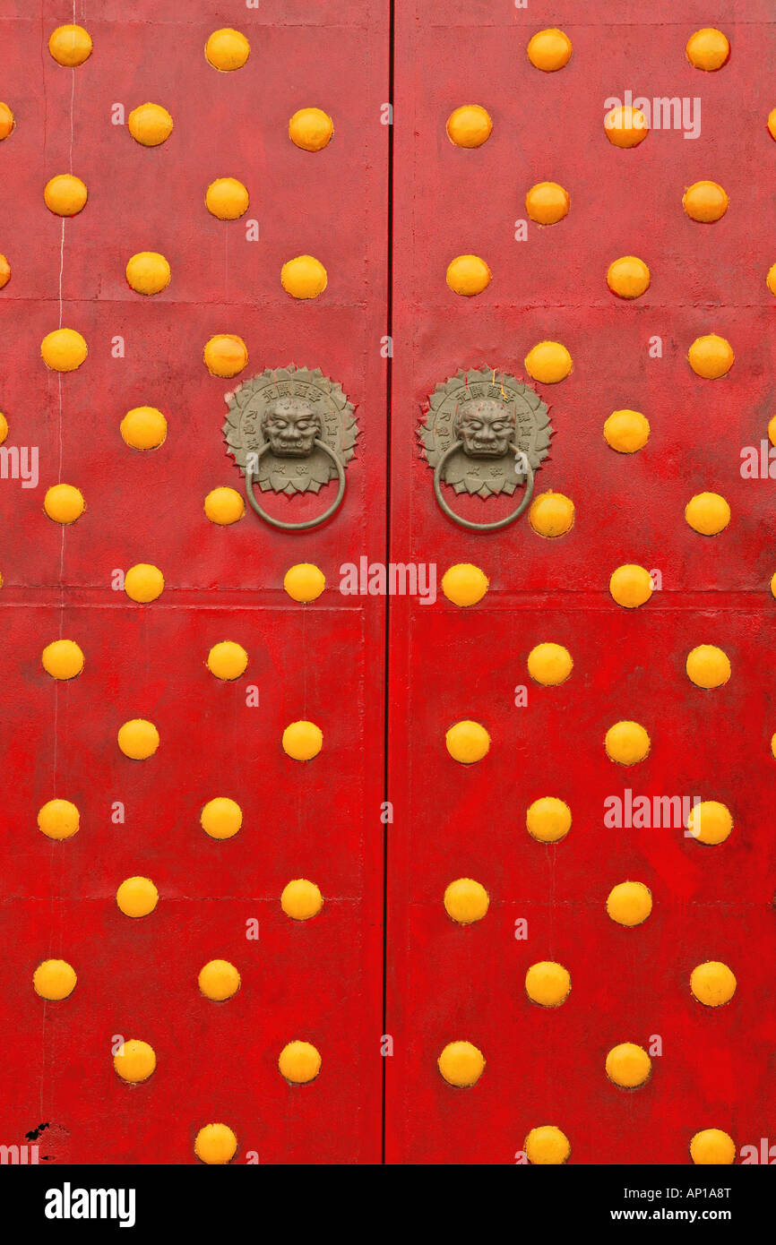 Tür des Tempels, Tor, doppelte Türen in rot mit runden gelben Dekorationen, Löwe Türklopfer, China, Asien Stockfoto