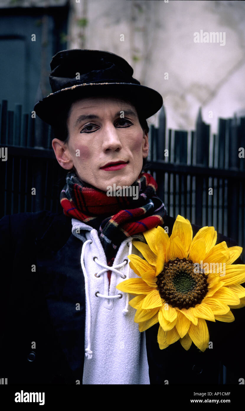 Parisian Straße weißes Gesicht Pantomime mit übergroßen gelben Sonnenblumen Knopfloch Stockfoto