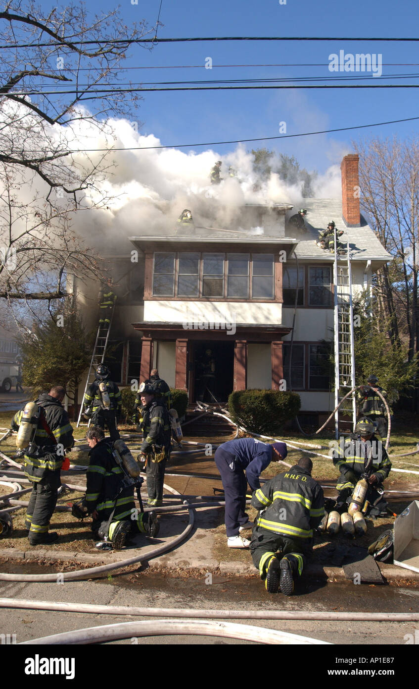Feuerwehrleute ändern Sauerstoffflaschen als die Schlacht ein großes Haus Feuer in New Haven CT USA Stockfoto