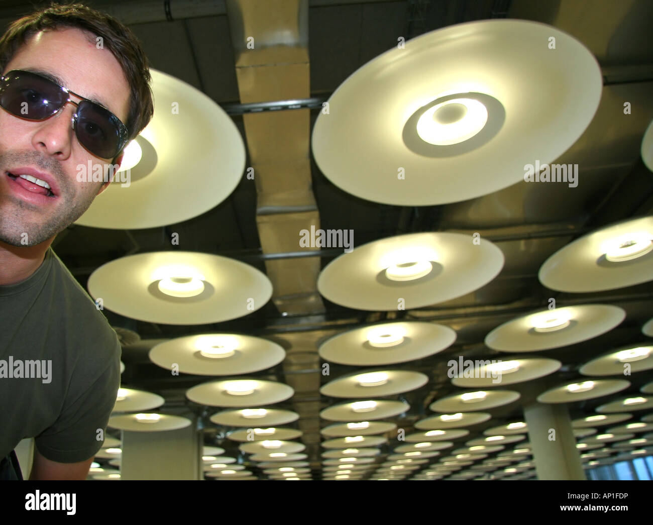 cool und hip Mann im Flughafen mit runden Lampen Stockfoto