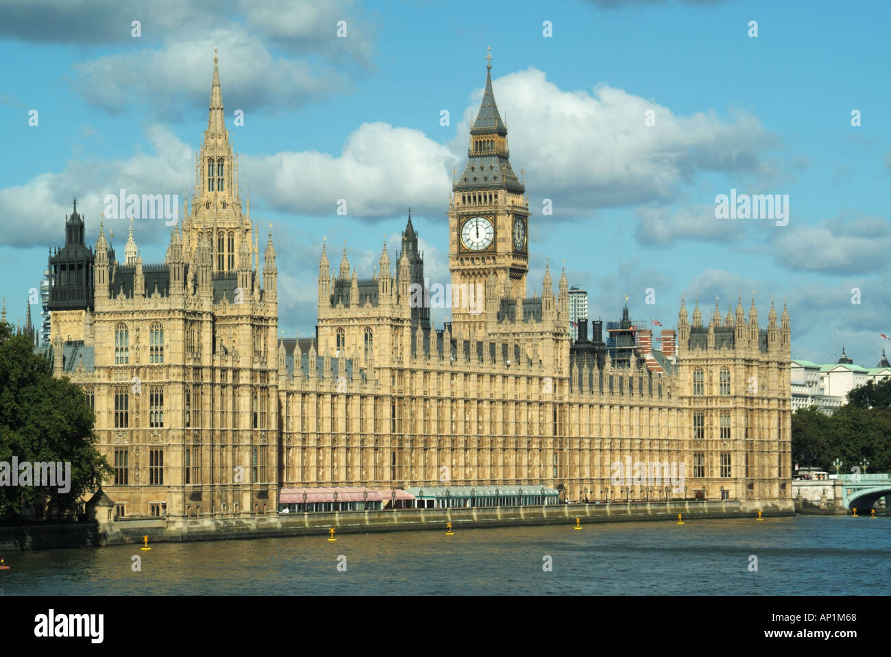 Houses of Parliament mit Big Ben ikonischem Blick auf London und die Themse, der die Uhr am Mittag an einem sonnigen Tag mit blauem Himmel in Westminster England, Großbritannien, anzeigt Stockfoto