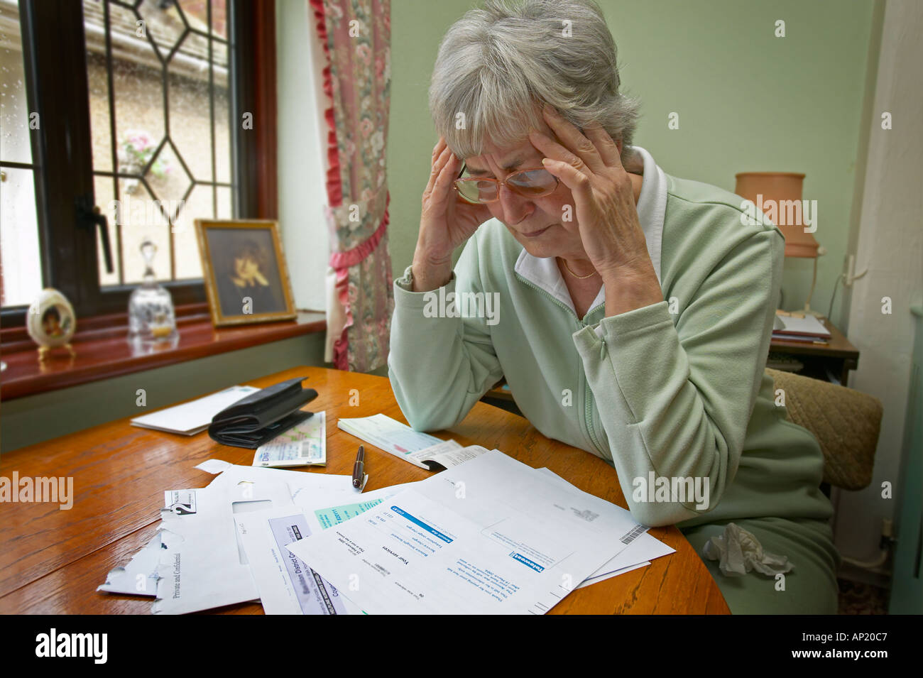 Rentnerin, die sich Sorgen macht, ihre Heizkosten und andere Rechnungen zu bezahlen. Stockfoto