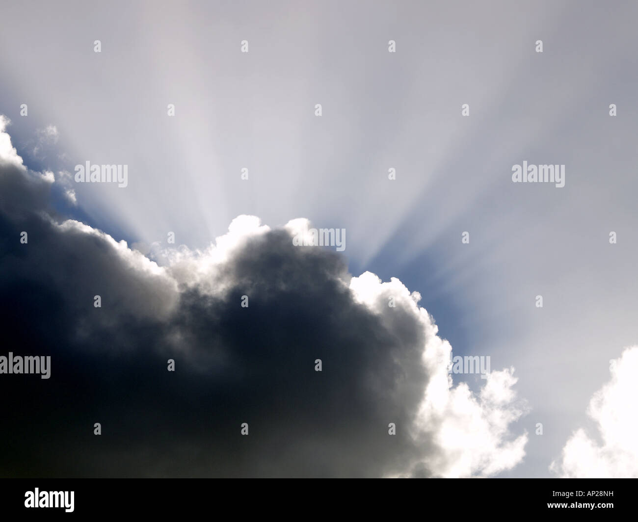 Sonnenstrahlen nach oben von hinten eine schwarze Wolke Stockfoto