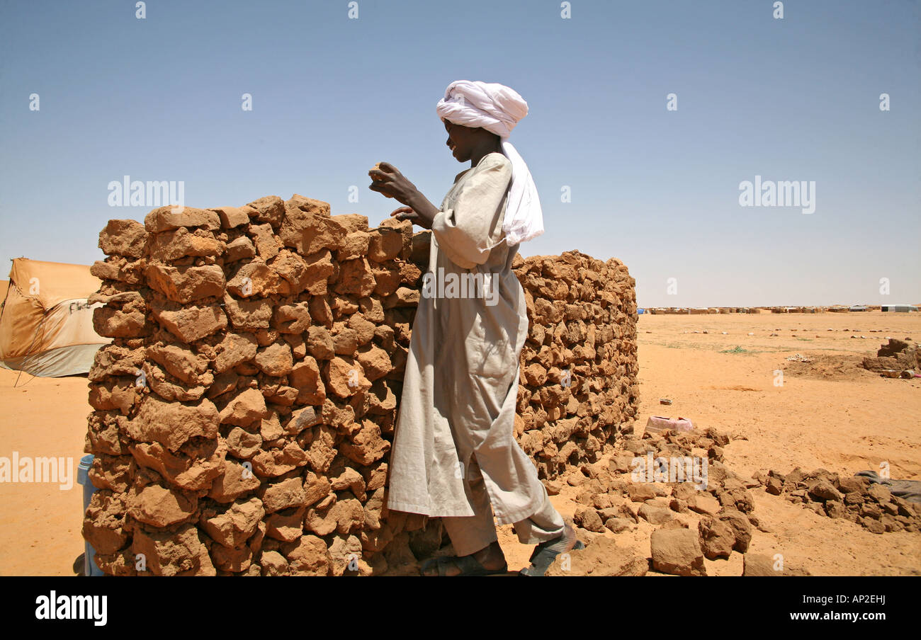 Flüchtling junge baut eine Mauer im Flüchtlingslager Stockfoto