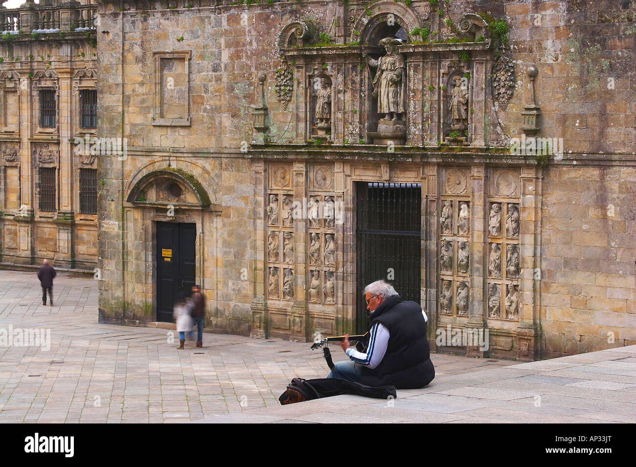 Mann spielt Gitarre vor Skulpturen von Meister Mateo, Puerta Santa, Praza da Quintana, Kathedrale Santiago de Compostela, Stockfoto