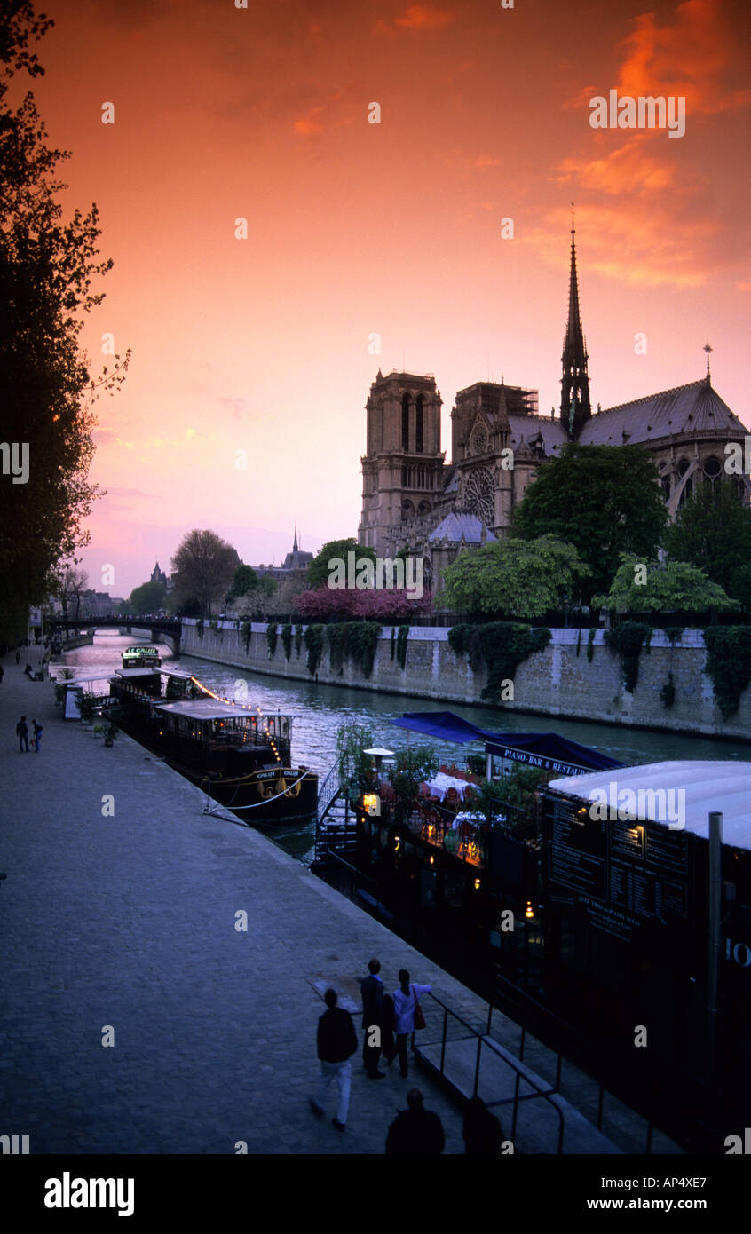 Ein Blick auf die Kathedrale Notre Dame, bei Sonnenuntergang in Paris Frankreich mit Booten entlang der Seine Stockfoto