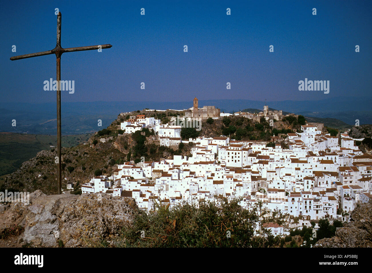Weiß getünchten Dorf auf einem Hügel Metall Kreuz links im Vordergrund Casares Andalusien Spanien Stockfoto