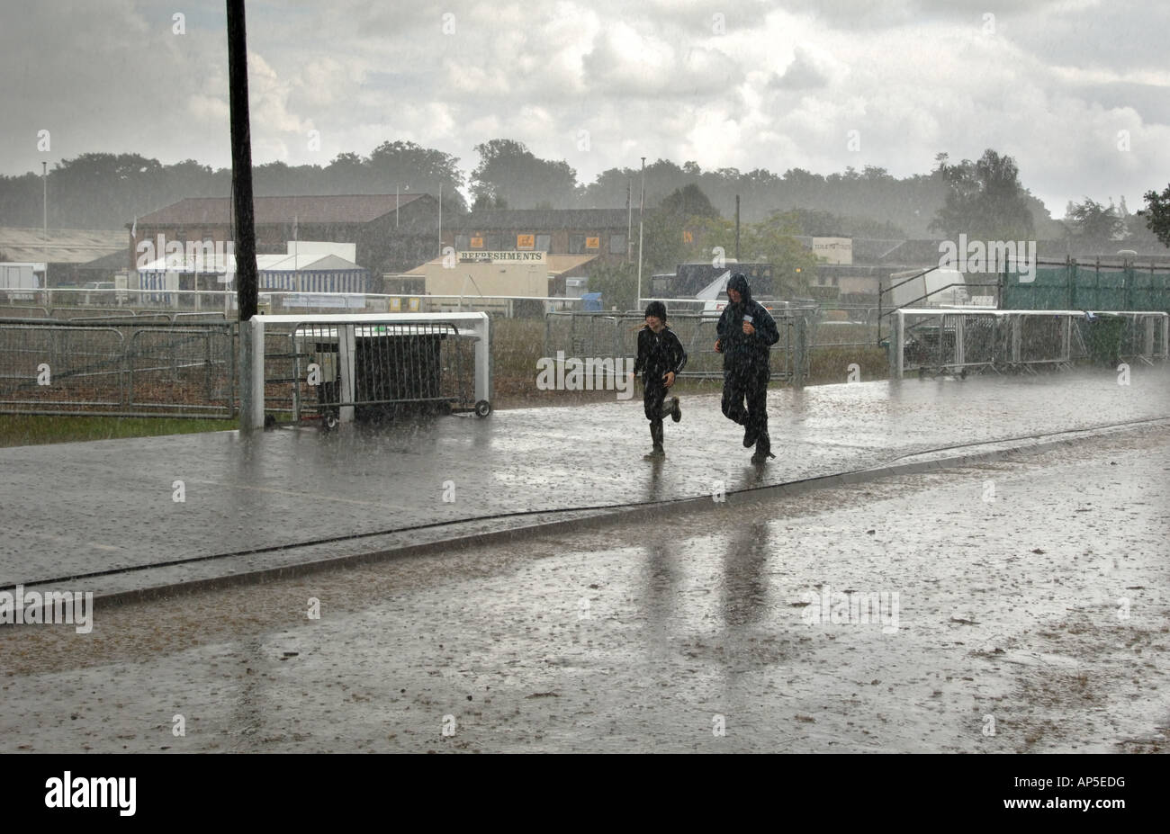 Zwei Personen laufen im Regen Sturm entlang einer Straße in England Stockfoto