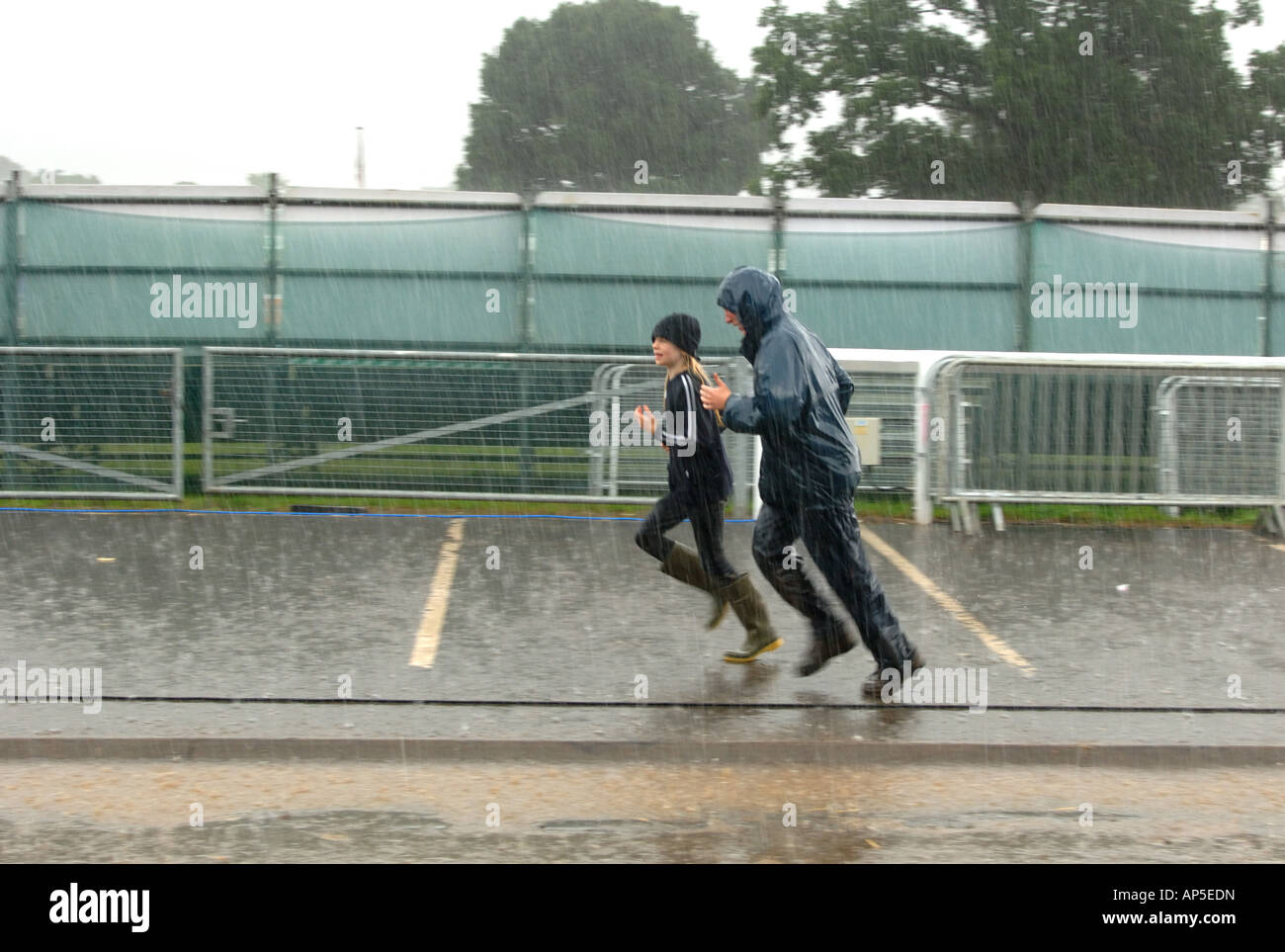 Zwei Personen laufen im Regen Sturm entlang einer Straße in England Stockfoto