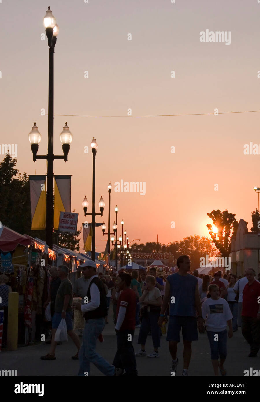 Schutzherren & Besucher von der Utah State Fair zu Fuß der Midway Einbruch der Dunkelheit nähert. Die Sonne ist fast untergegangen & alles ist im Schatten. Stockfoto