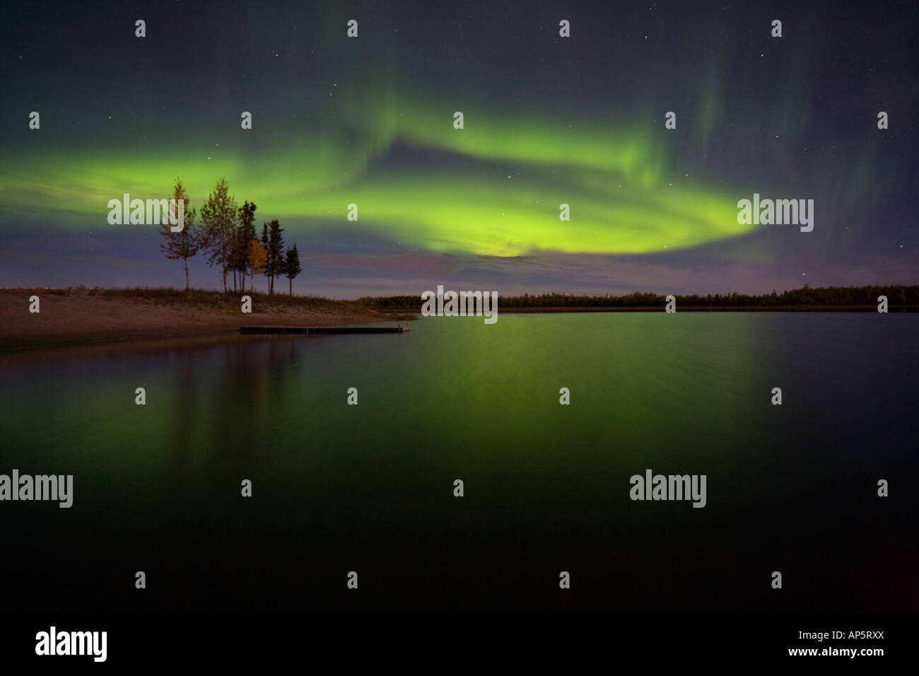 Sauberes Bild eine beeindruckende Darstellung der Aurora Borealis über noch See und Bäume in der Nähe von Fairbanks, Alaska Stockfoto