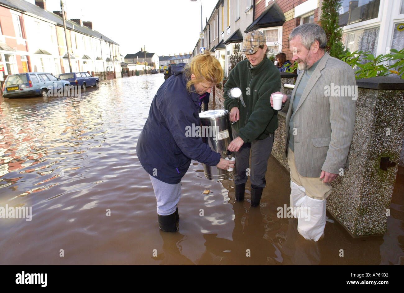 Freiwillige nehmen eine Urne aus Tee, Hausbesitzer, deren Häuser überflutet nach Starkregen in Newport South Wales UK wurden Stockfoto