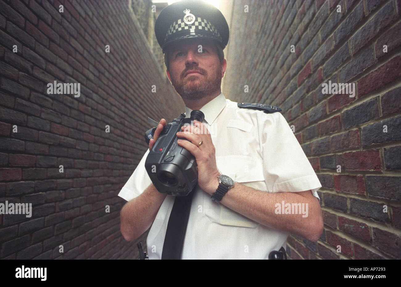 Britischer Polizist, die Überwachung von Ereignissen mit einer Videokamera Bild von Andrew Hasson 1997 Stockfoto