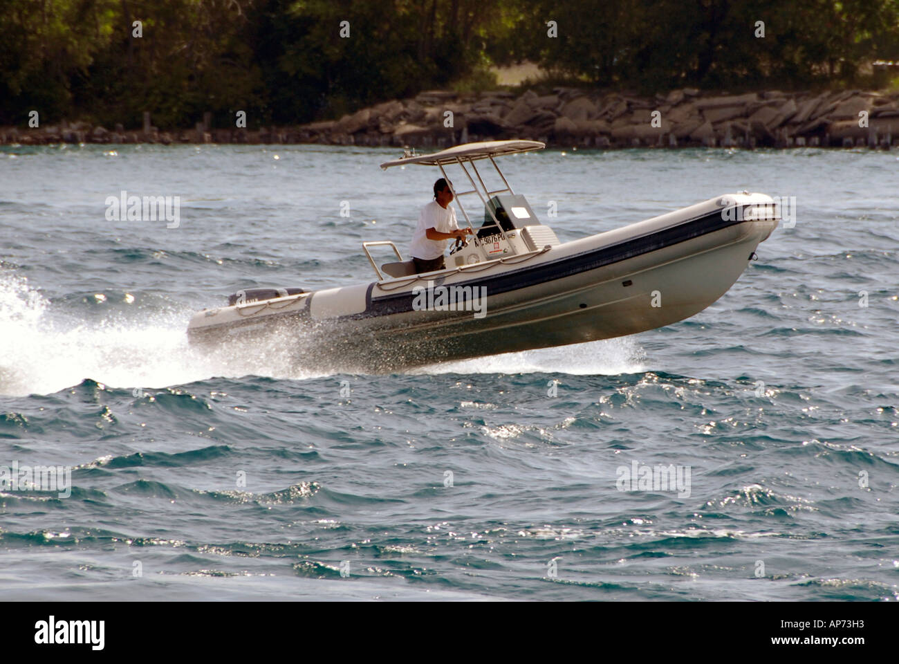Mann fährt ein kleines Sportboot in rauen Gewässern Stockfoto