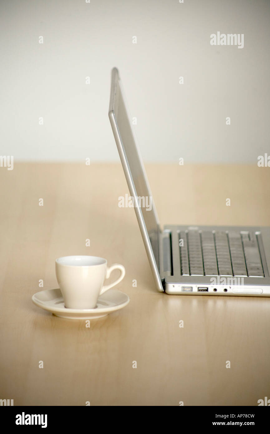 Laptop-Computer mit Tasse Kaffee auf modernen Schreibtisch einfach sauber vertikalen Raum für Typ Stockfoto