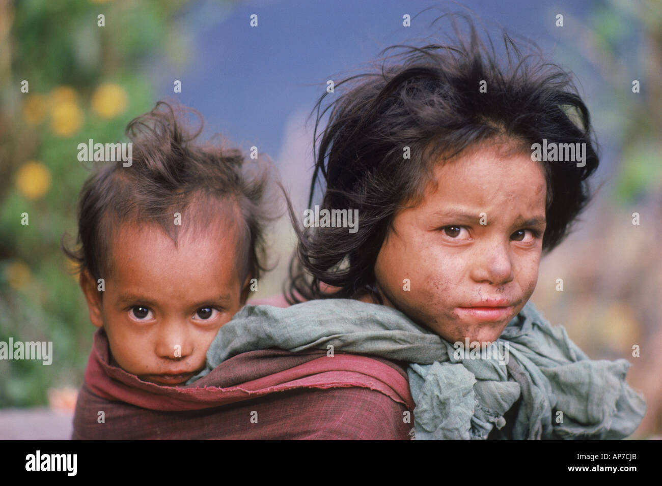 Mädchen tragen ihren kleinen Bruder oder eine Schwester in hintere Schlinge im Himalaya Dorf in Nepal Stockfoto