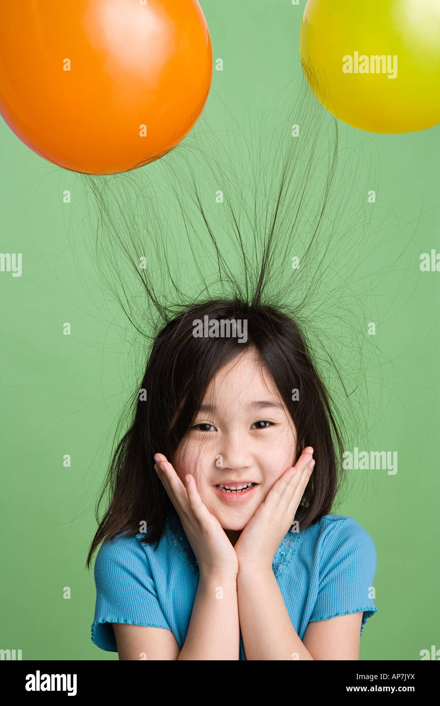 Mädchen mit Haaren festhalten an Luftballons Stockfoto