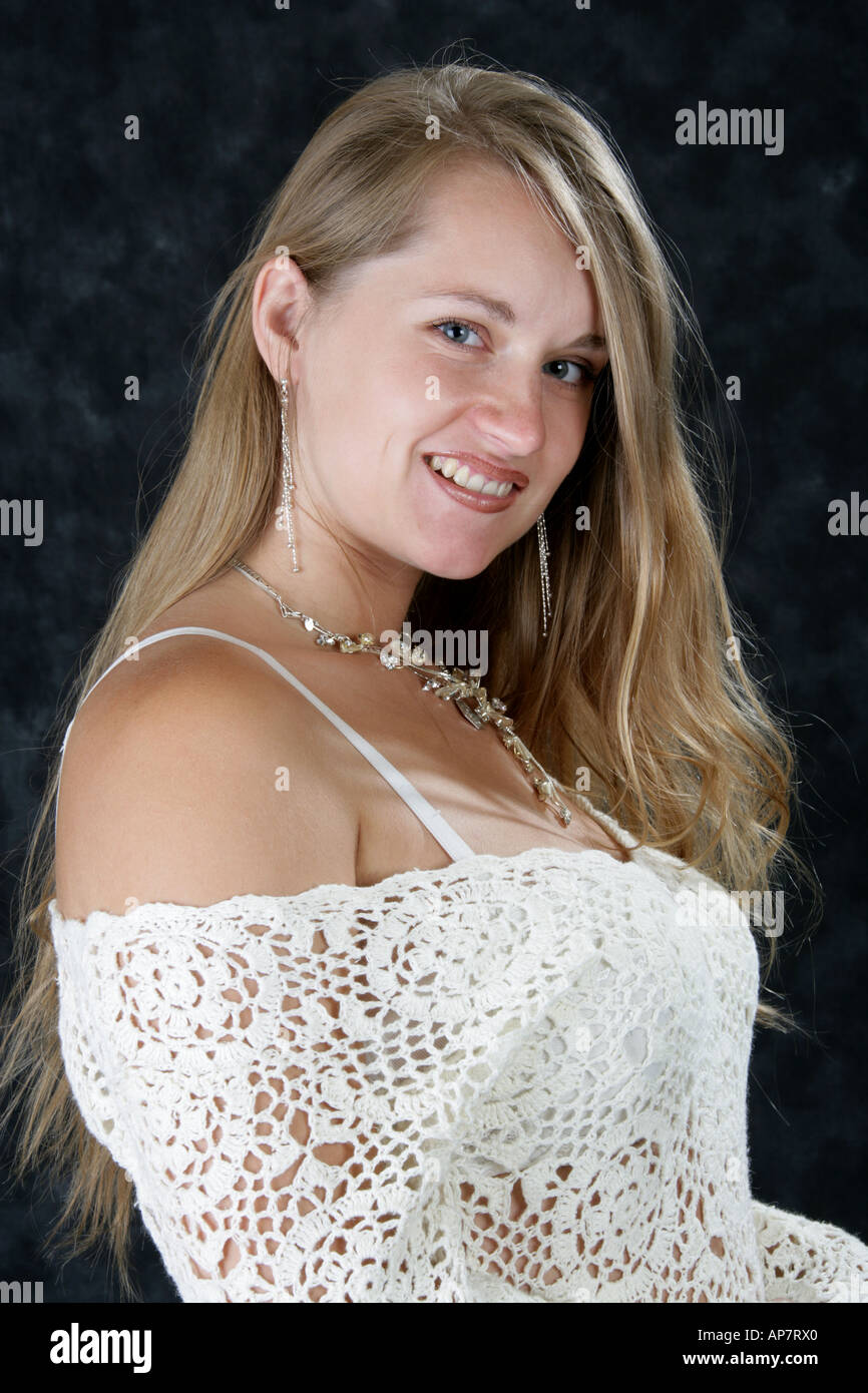 Porträt eines jungen Mädchens mit langen blonden Haaren trug eine weißes Spitzenkleid Stockfoto