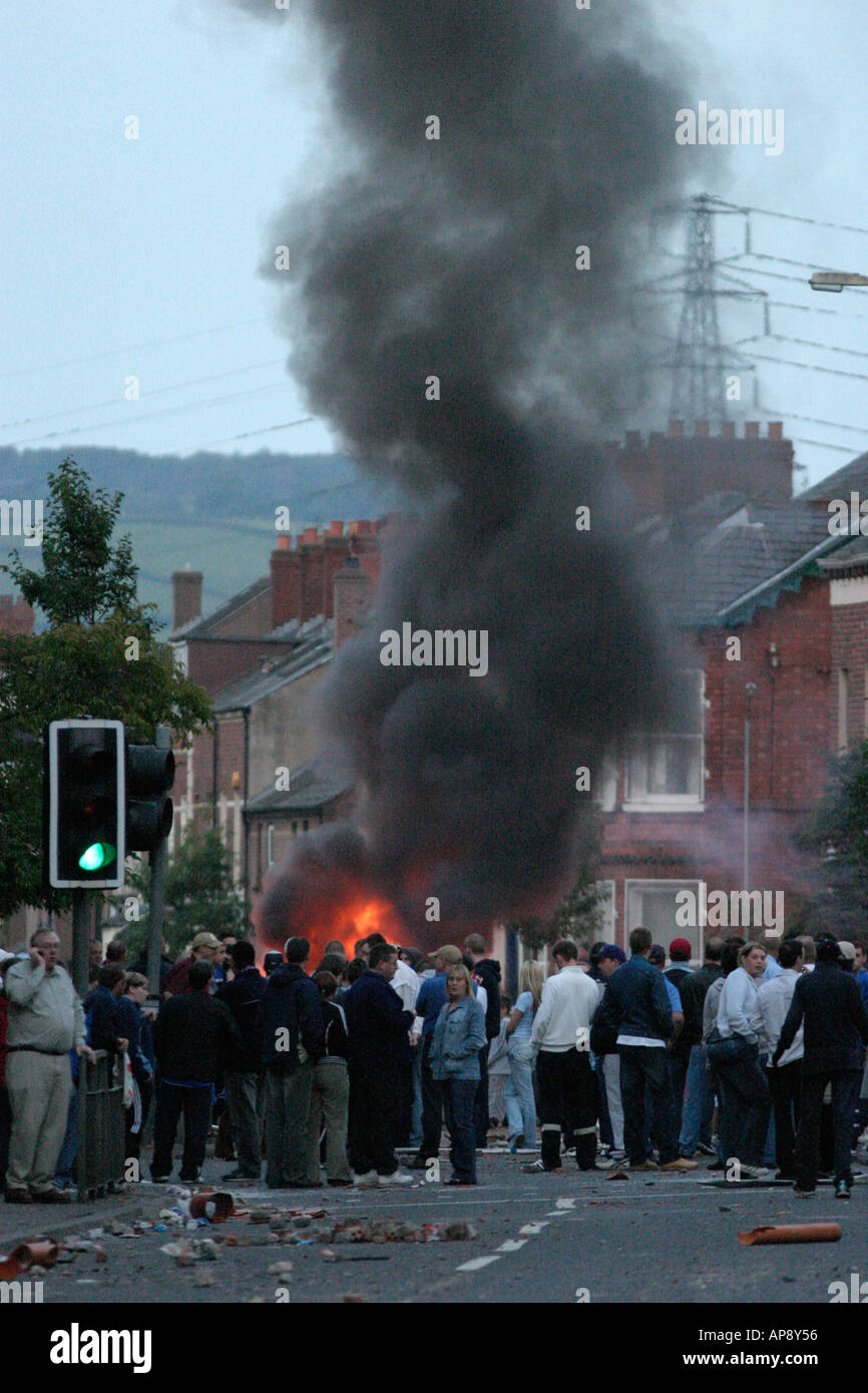 Loyalist Demonstranten blockieren die Straße vor den brennenden Fahrzeug an der Albertbridge Road Belfast Nordirland Stockfoto