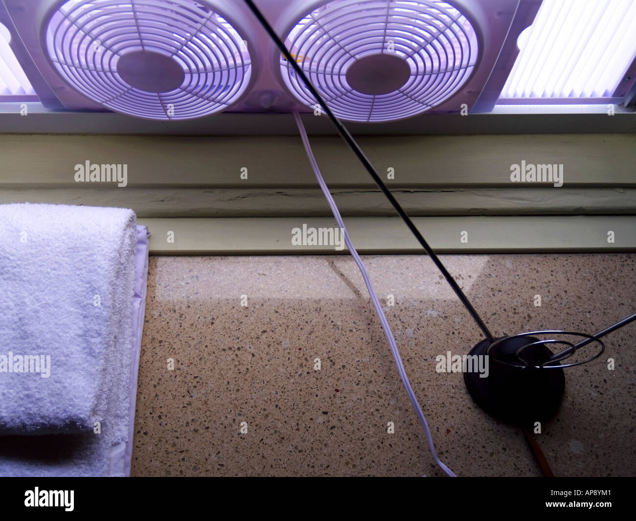 TV-Antenne, Twin-Fan Fenster Kühler und weißes Handtuch auf Marmor Oberfläche unter Fenster. Stockfoto