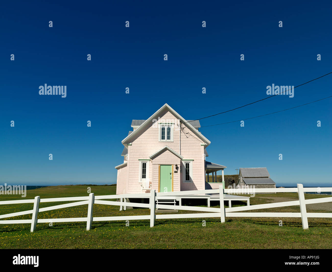 Kanada Quebec Gaspesie Rivière la Madeleine Rosa Haus und mit weißen Zaun vor blauem Himmel Stockfoto