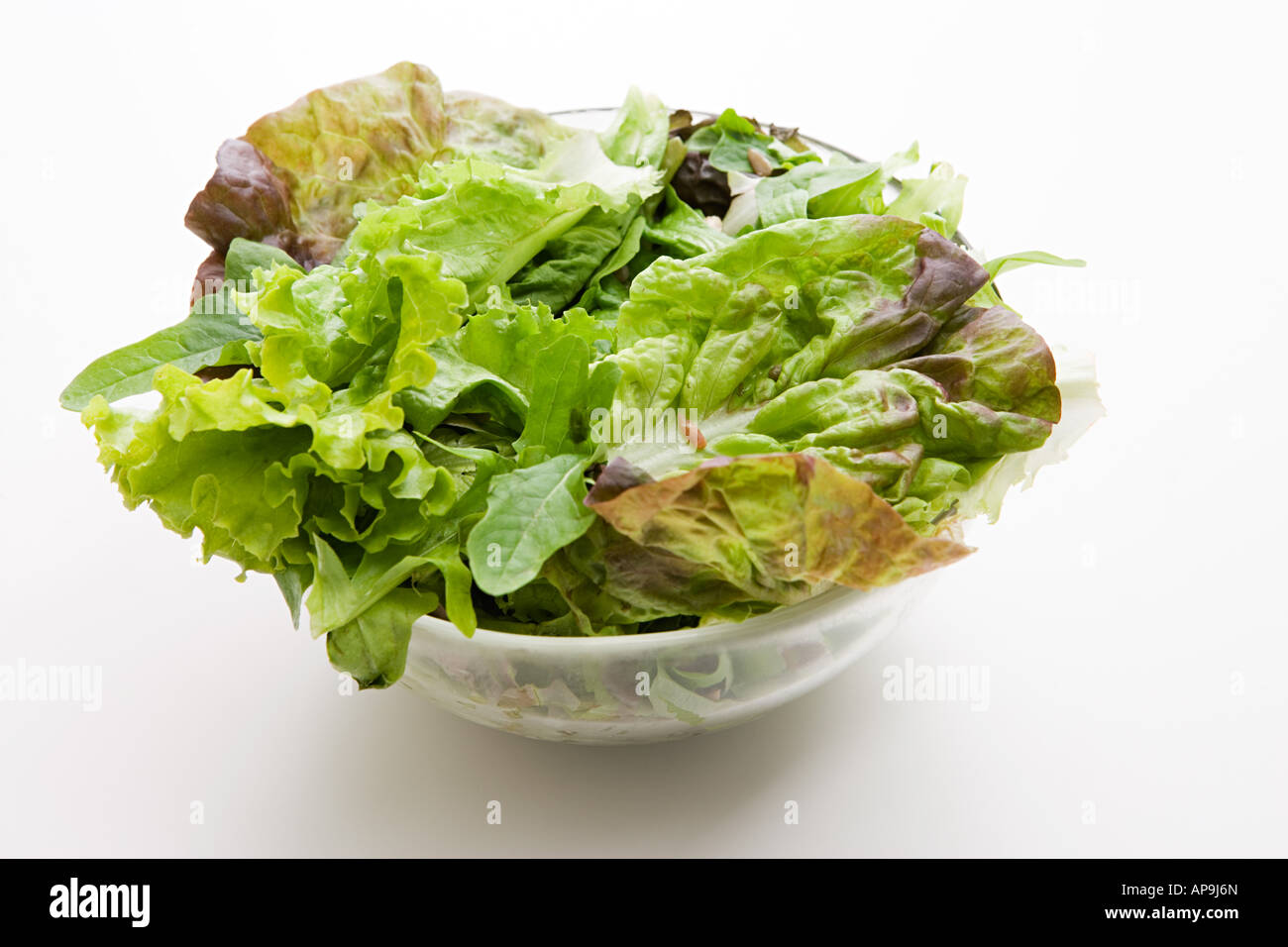 Salat in eine Schüssel geben Stockfoto