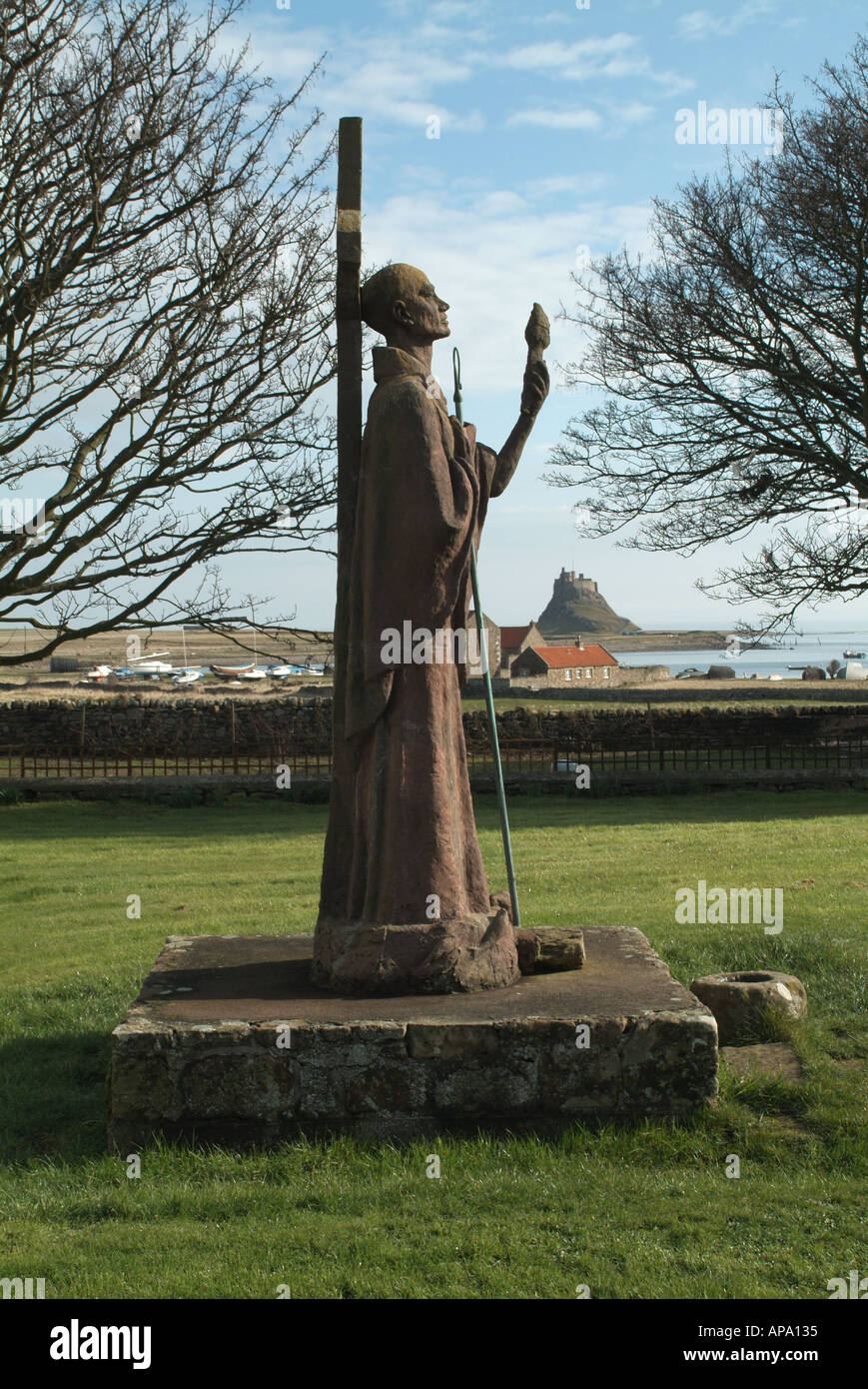 Statue von St. Aidan im Profil mit Lindisfarne Burg im Hintergrund, Lindisfarne Northumberland, England, UK. Stockfoto