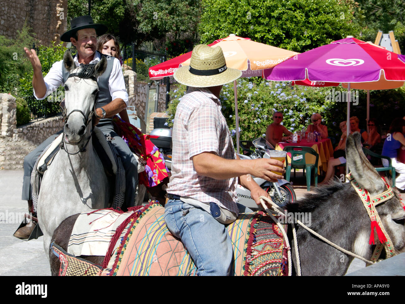 Mann auf dem Pferd begrüßt Mann mit Strohhut auf Maultier mit Glas in der Hand auf den Mijas Feria Spanien 2006 Mann auf dem Pferd sitzen Stockfoto