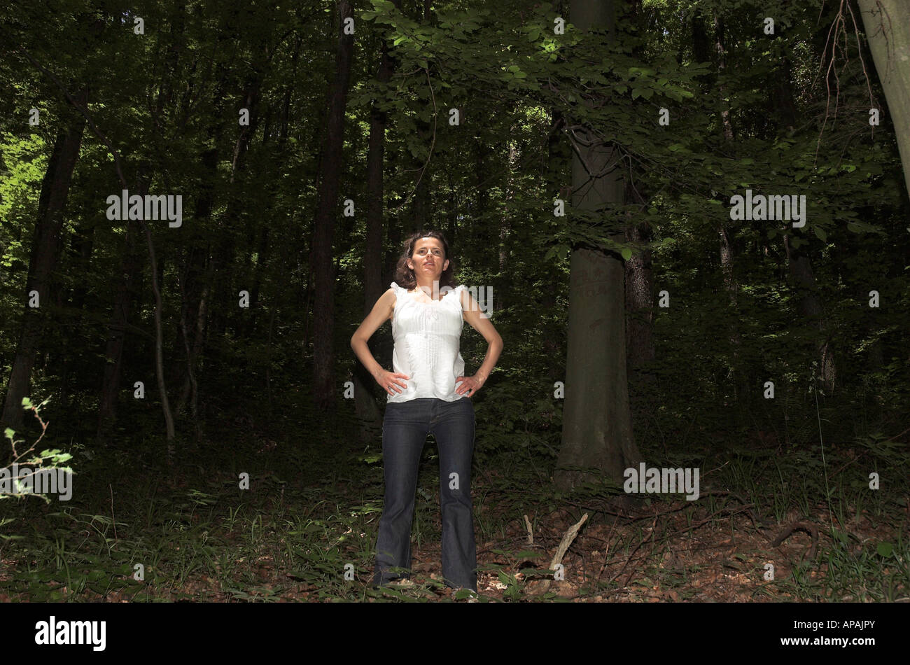 Junge Frau allein im Wald wegschauen Stockfoto
