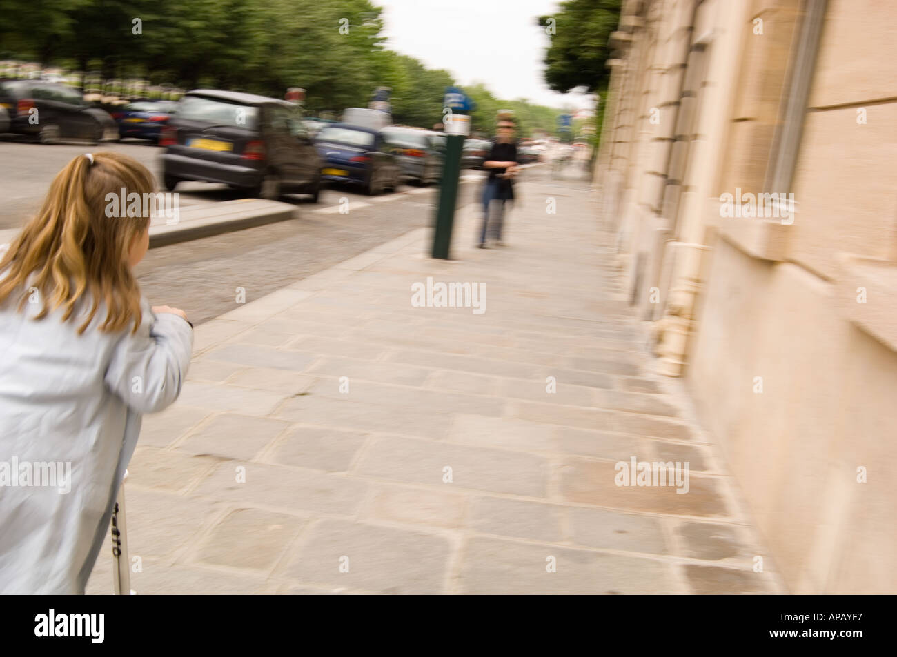 Horizontale Farbbild eine langhaarige Blondine auf einem Roller rollten einer Paris Straße vom Betrachter Stockfoto