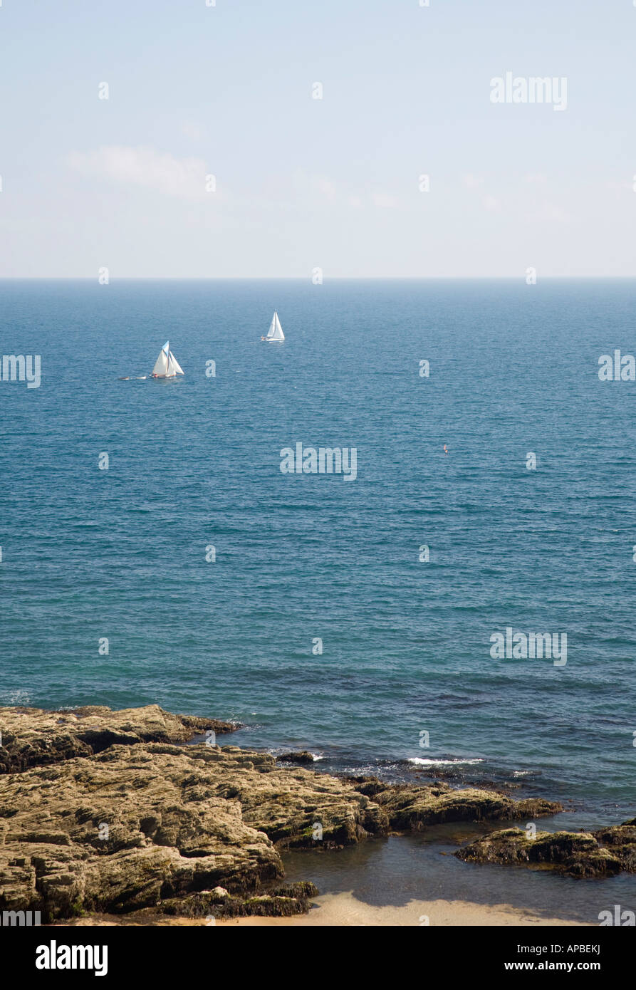 Yachten in der Ferne Segeln an der Küste Stockfoto