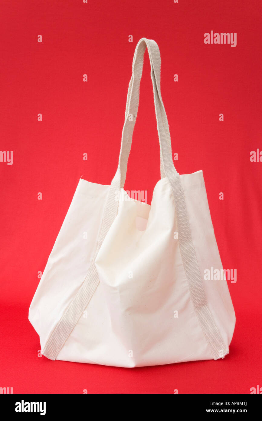 Wieder verwendbare natürliche weiße Baumwolle Shopping Bag auf einem roten Hintergrund von Seite isoliert. England Großbritannien Großbritannien Stockfoto