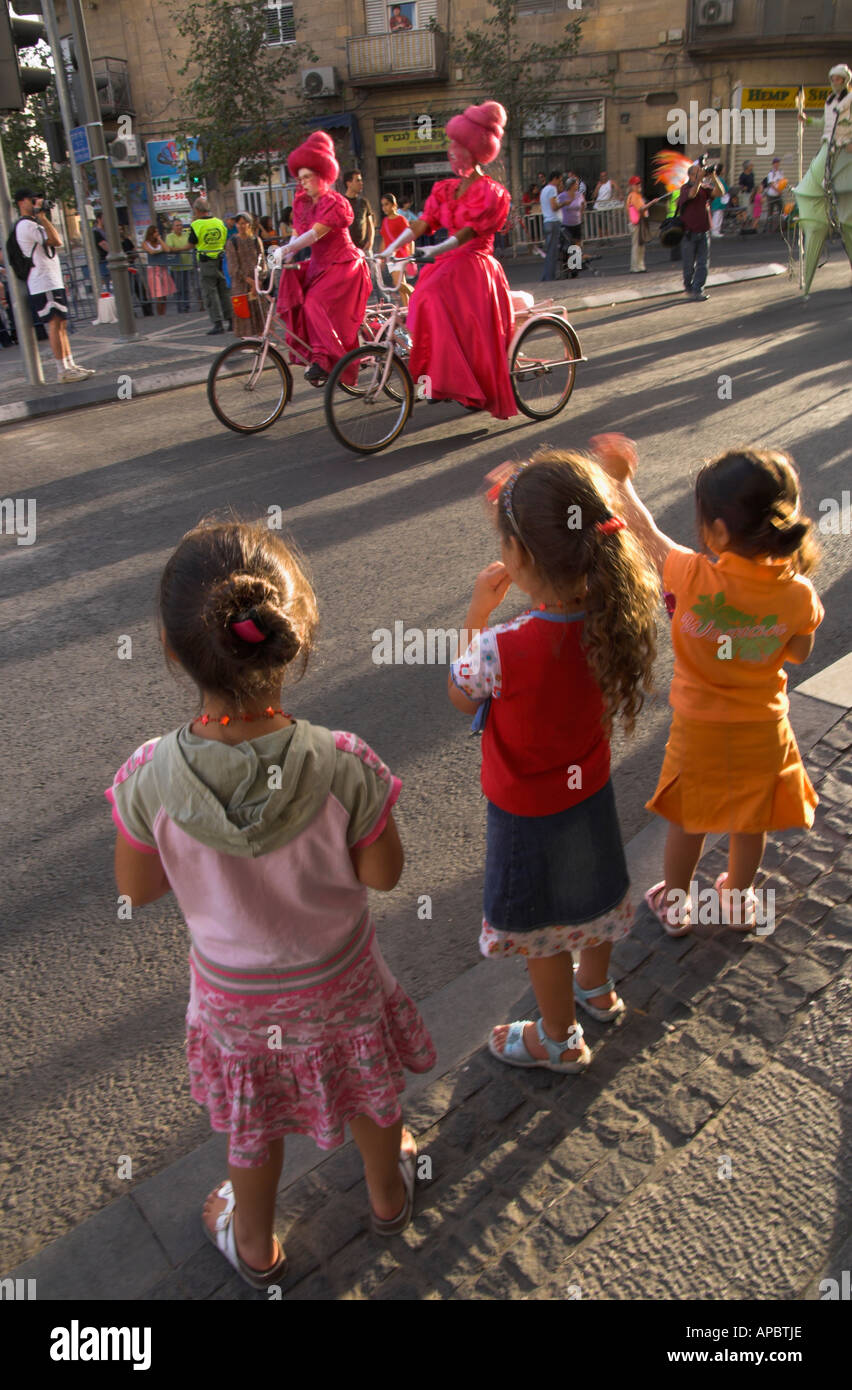 Israel Jerusalem City Center jährliche Jerusalem gehen 3 junge Mädchen winken 2 Radfahrer in rosa Kleider tragen Frauen verkleidet Stockfoto