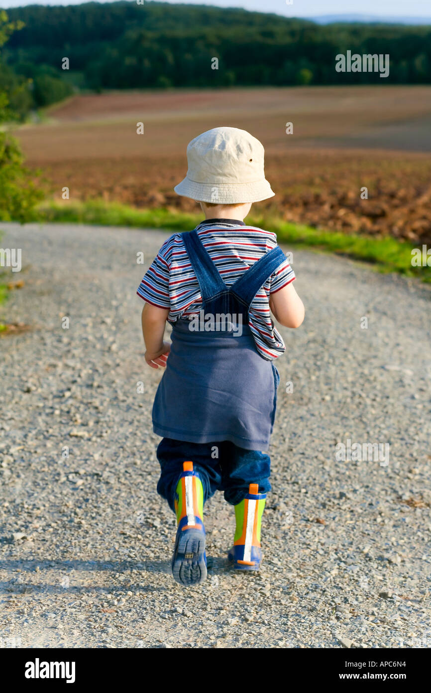 Ein drei Jahre alter Junge ist auf einer Strecke Fuß. Stockfoto