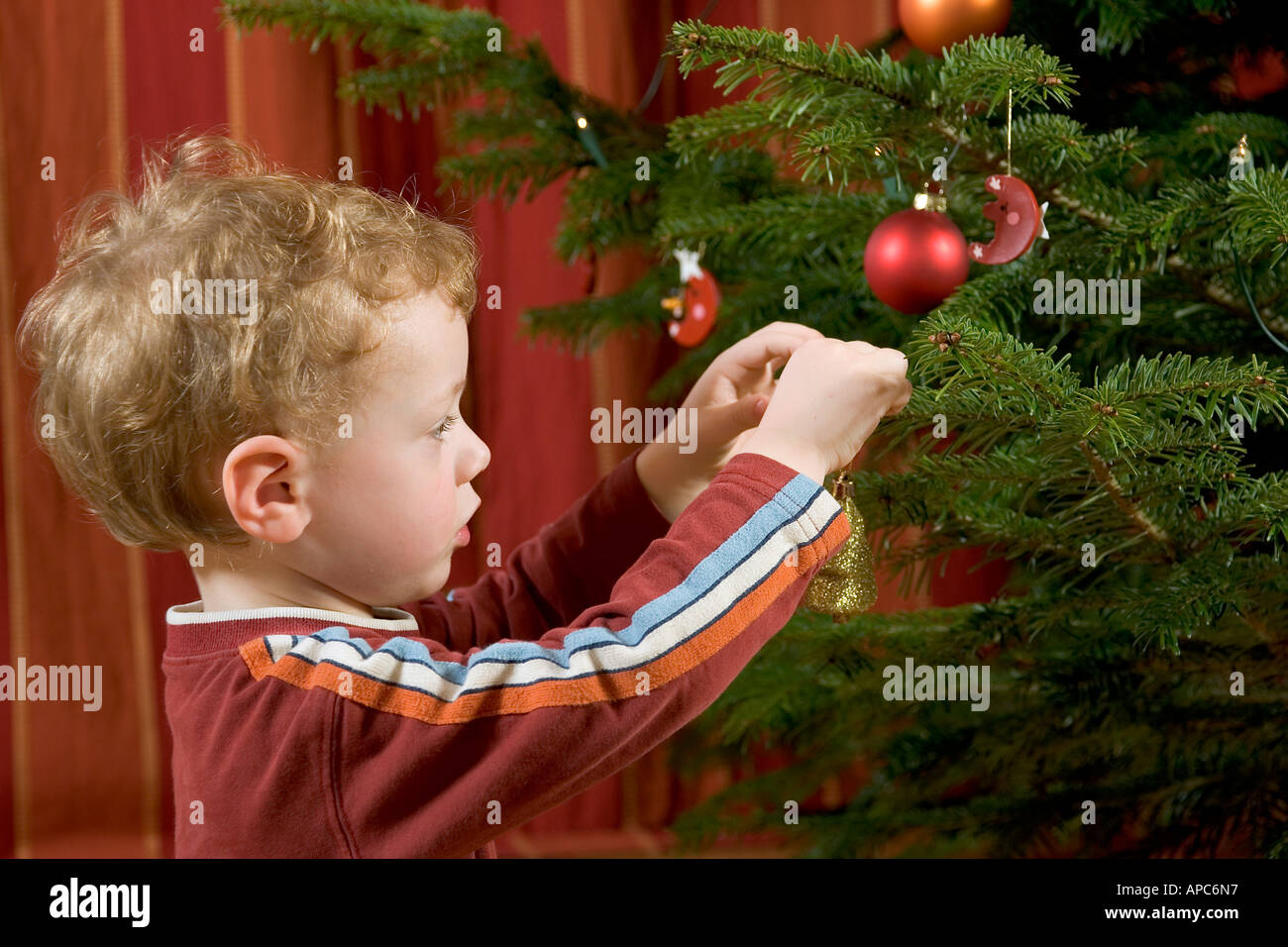 Ein kleiner Junge ist der Weihnachtsbaum schmücken. Stockfoto