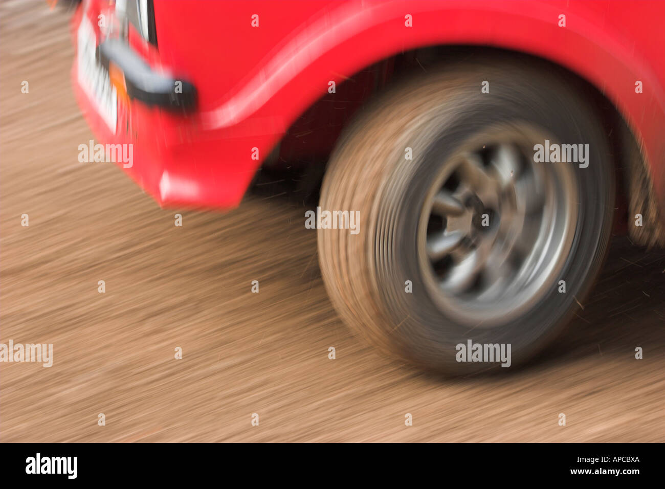 Nahaufnahme der Rallye Auto Vorderrad Beschleunigung übergebenen Bewegungsunschärfe vermittelt Gefühl von Geschwindigkeit Stockfoto