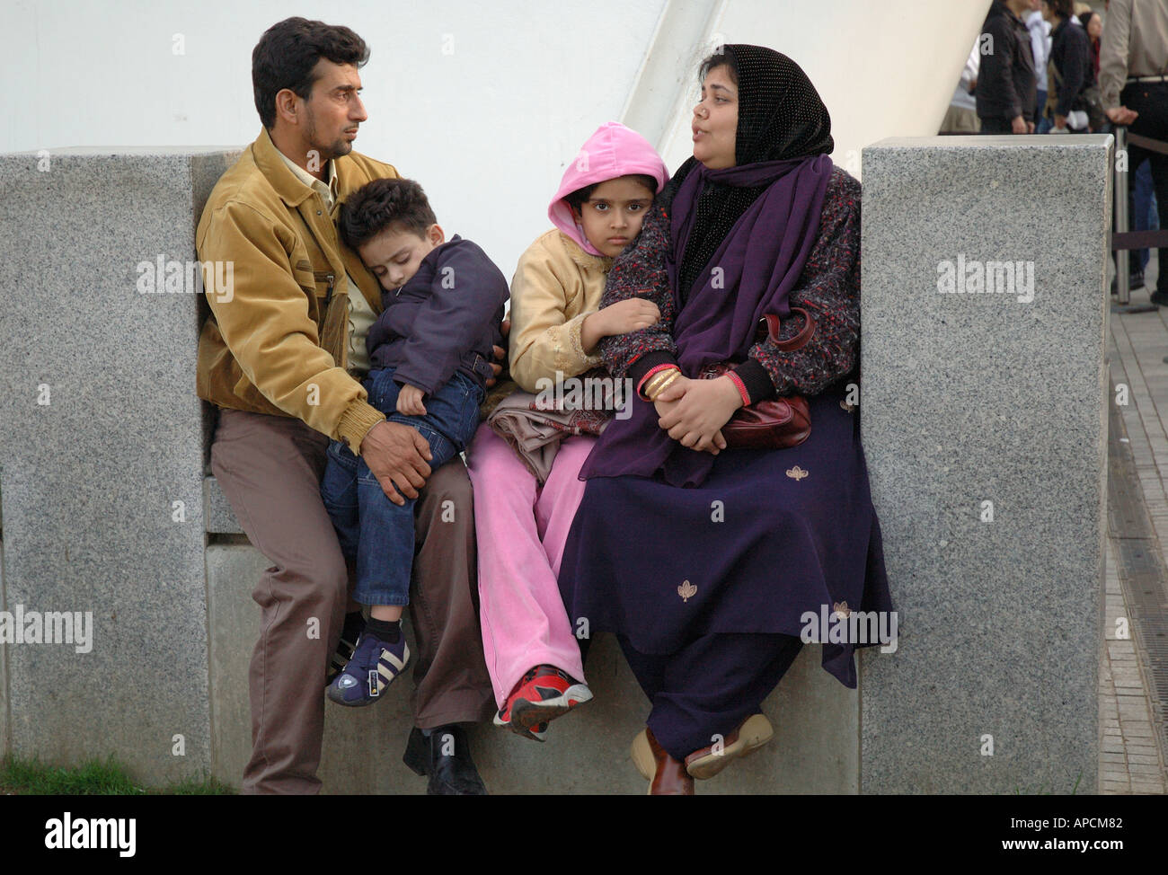 Asiatische Familiengruppe ruhen, schlafen in South Bank London warten. Stockfoto