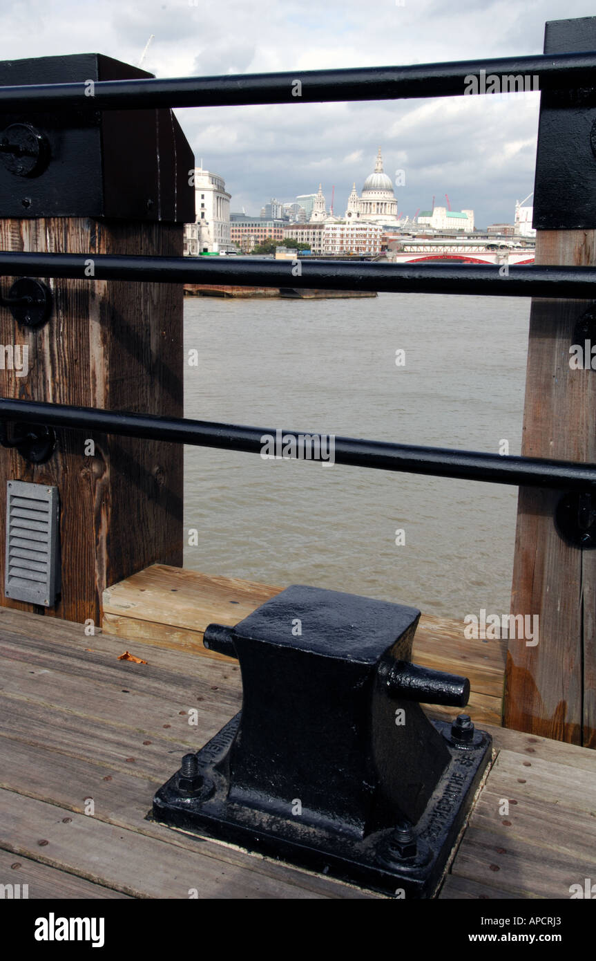 Blick durch Geländer über Themse Richtung St. Pauls Kathedrale mit Pflaster und Poller im Vordergrund south bank London uk Stockfoto