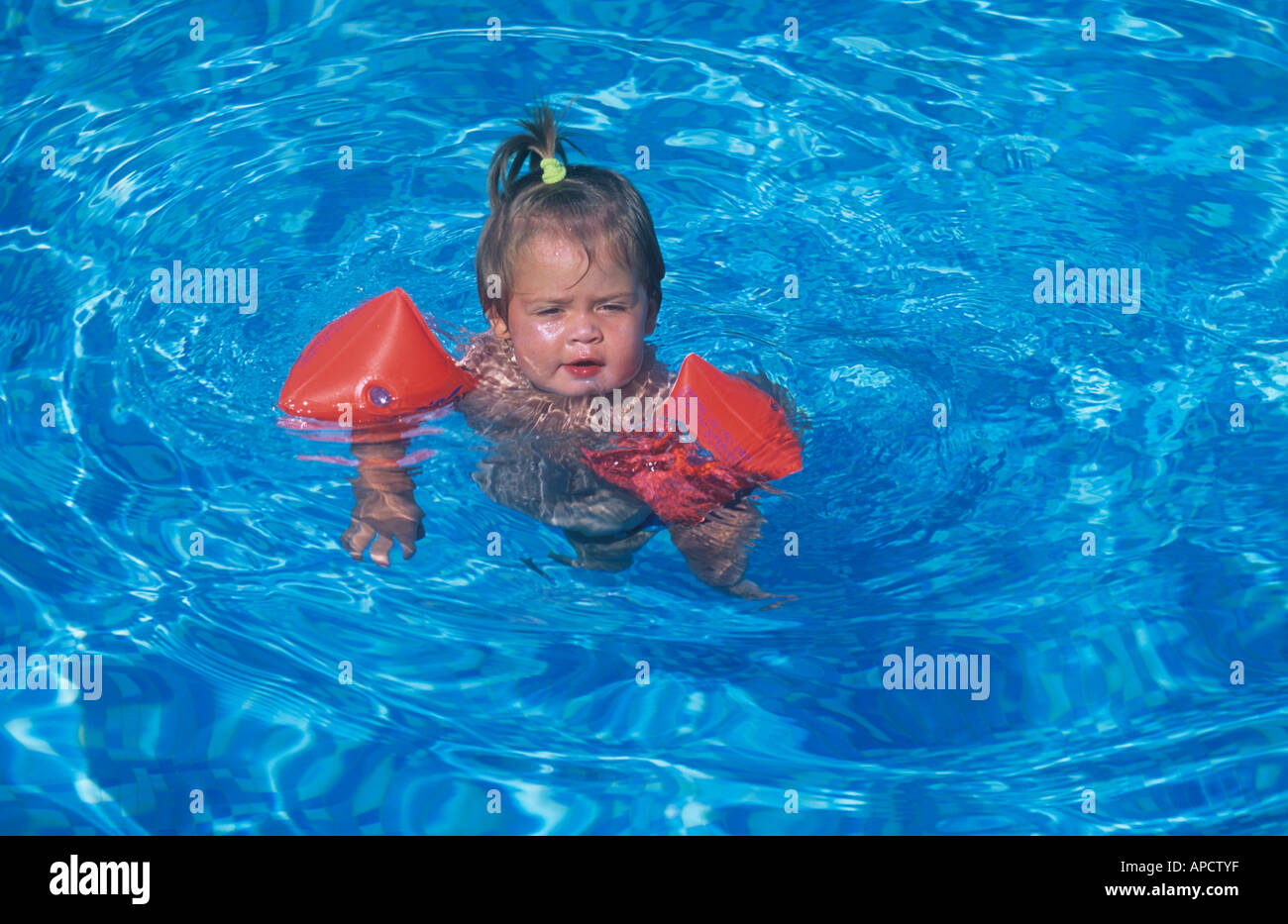 Baby Mädchen, Alter 19 Monate, im Schwimmbad, mit Wasser-Flügel Stockfoto